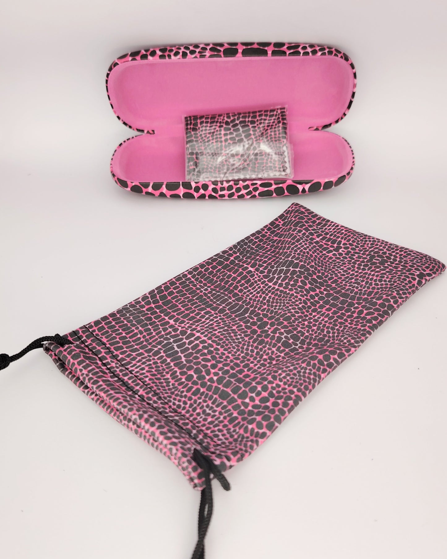 pack para gafas formado por estuche rígido, funda de tela blanda y gamuza limpia gafas, todo ello en print rosa y negro