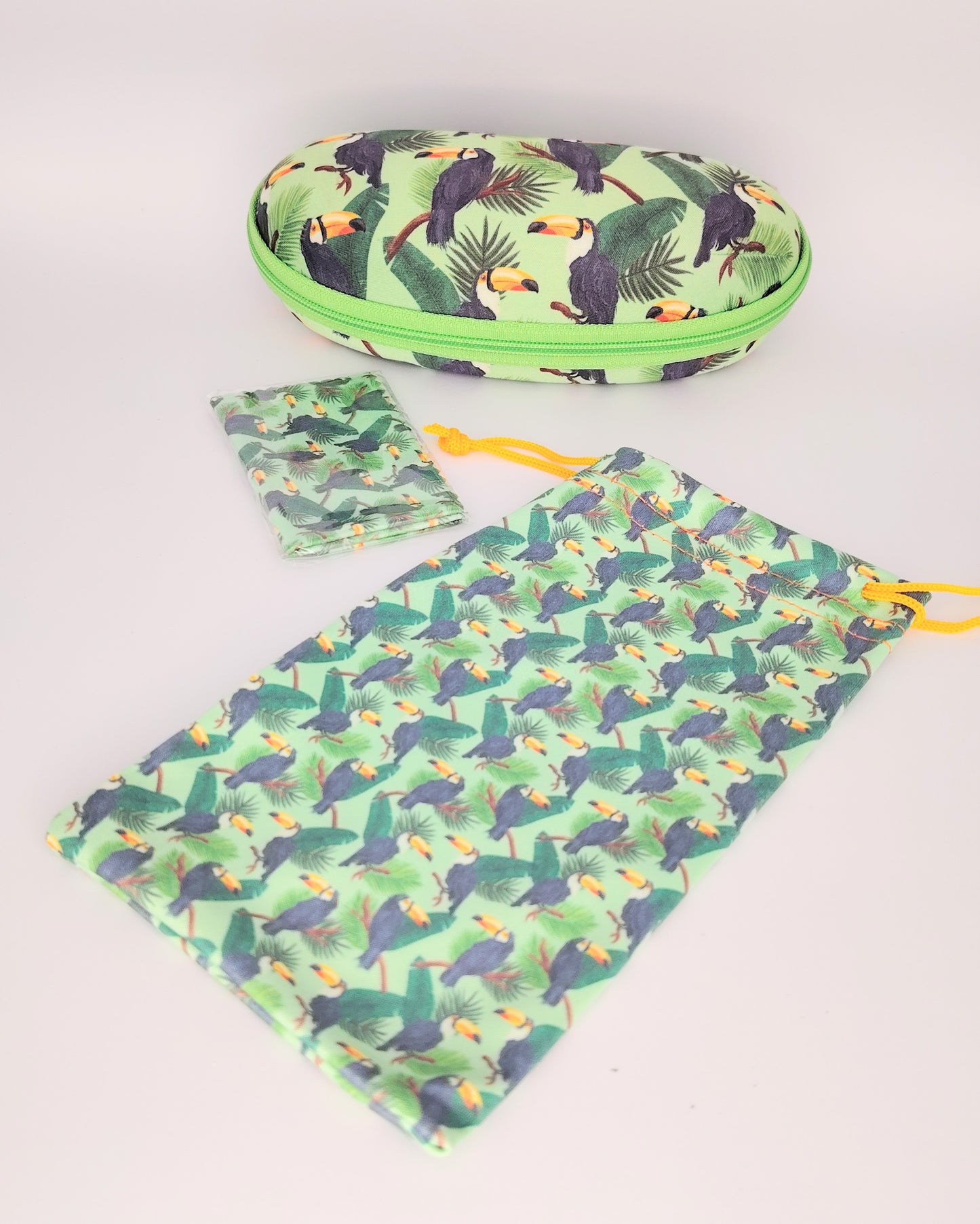 pack para gafas formado por estuche de cremallera, funda de tela blanda y gamuza limpia gafas, todo ello en estampado de tucanes en tono verde negro amarillo y marrón