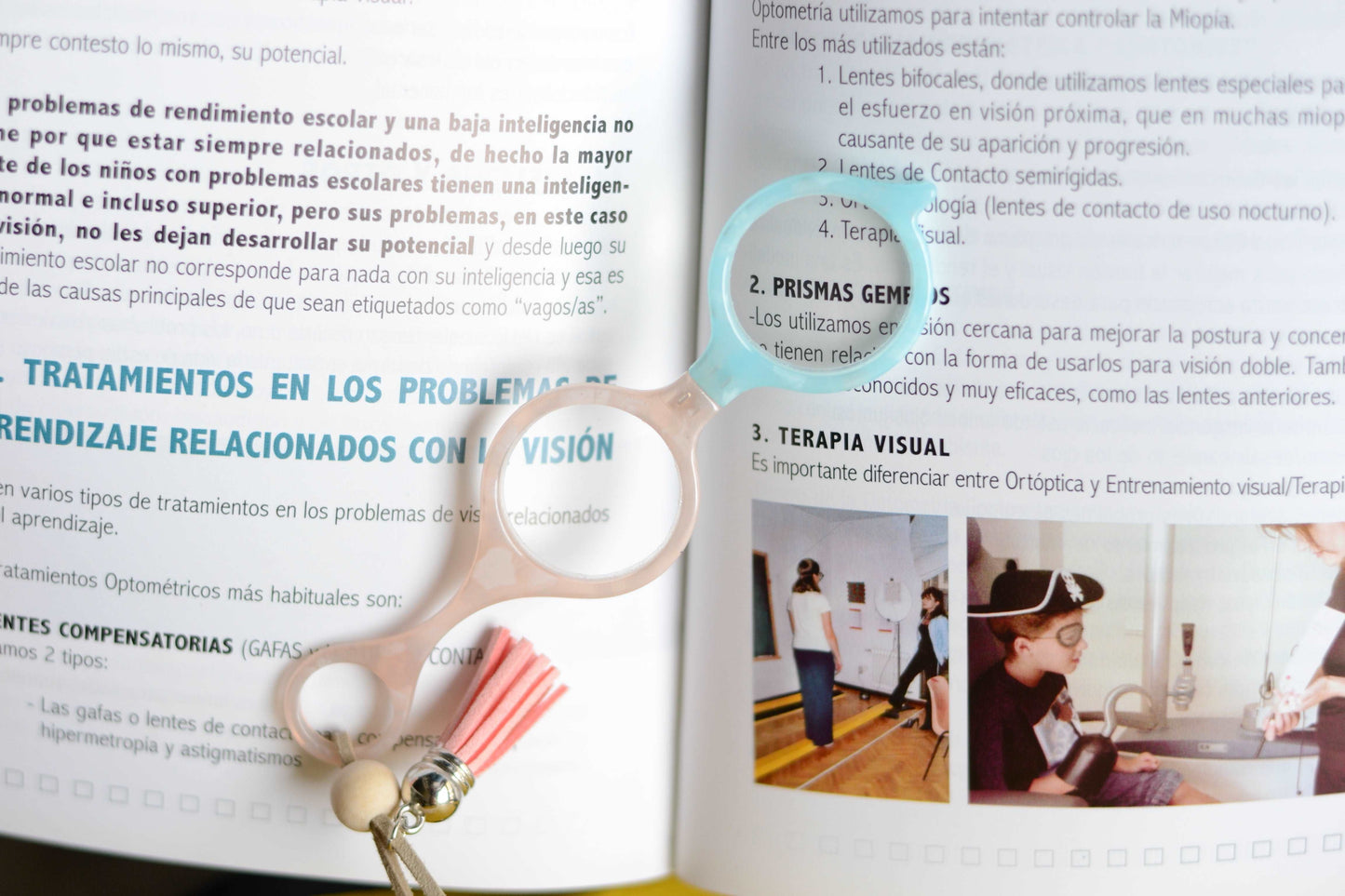 colgante lupa impertilente en tonos beige y azul claro con correa de cuero abalorios decorativos y borla a juego para llevar siempre a mano con un toque elegante y funcional