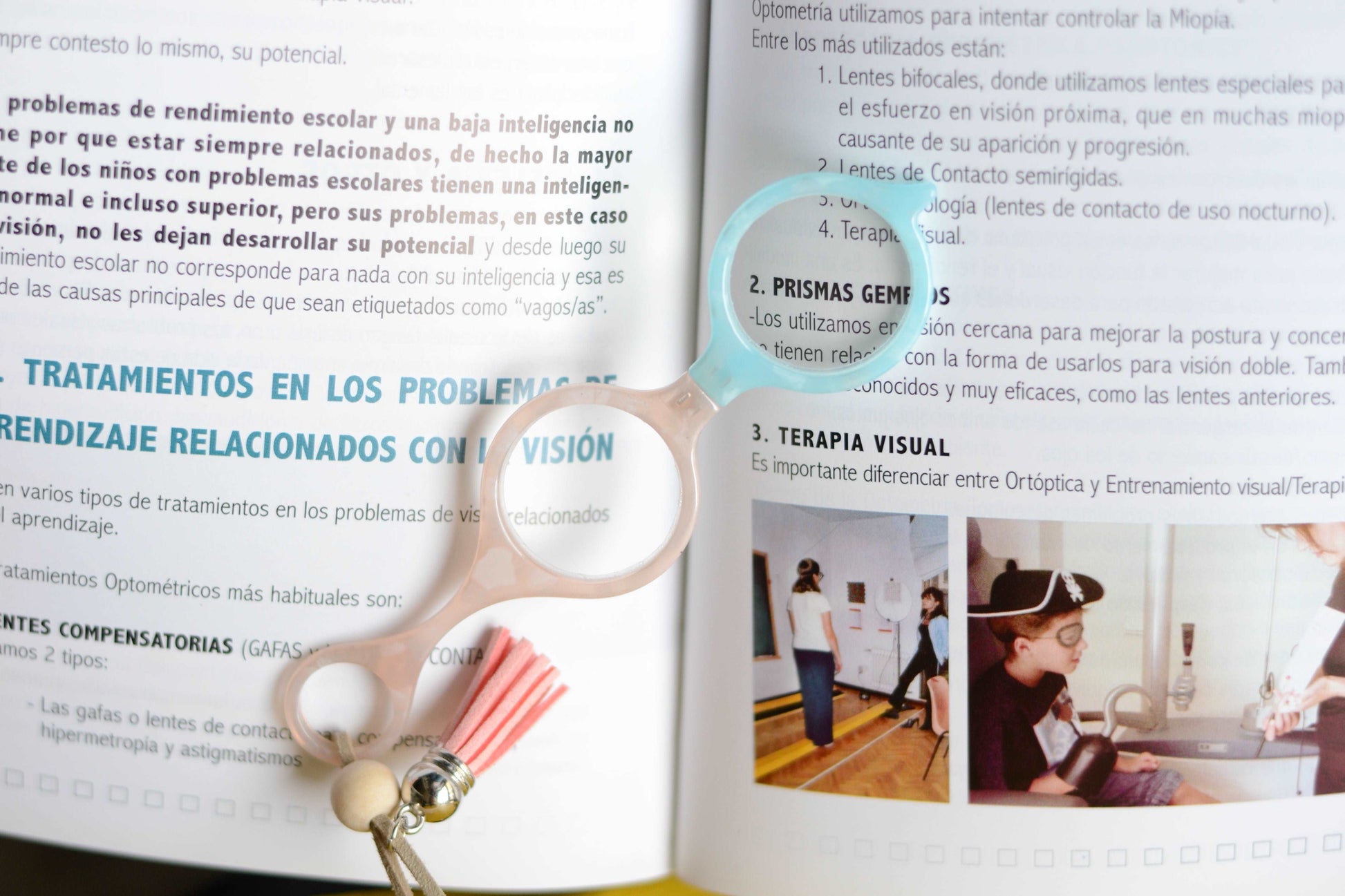 colgante lupa impertilente en tonos beige y azul claro con correa de cuero abalorios decorativos y borla a juego para llevar siempre a mano con un toque elegante y funcional