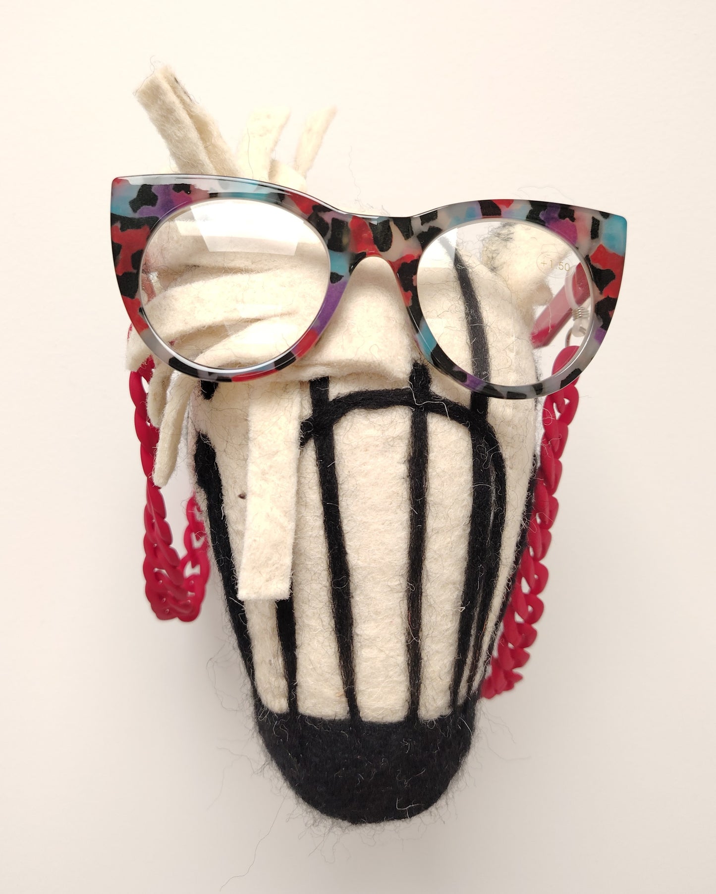 gafas premontadas para presbicia modelo k eyes k38-catherine con montura cat-eyes en acetato estampado multicolor, acompañadas de una cadena cuelga gafas de eslabones gruesos en rojo mate