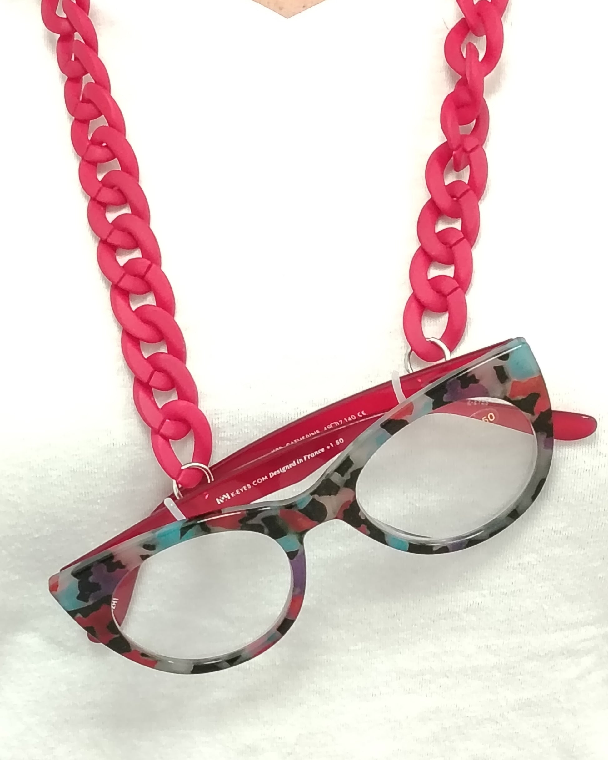 gafas premontadas para presbicia modelo k eyes k38-catherine con montura cat-eyes en acetato estampado multicolor, acompañadas de una cadena cuelga gafas de eslabones gruesos en rojo mate