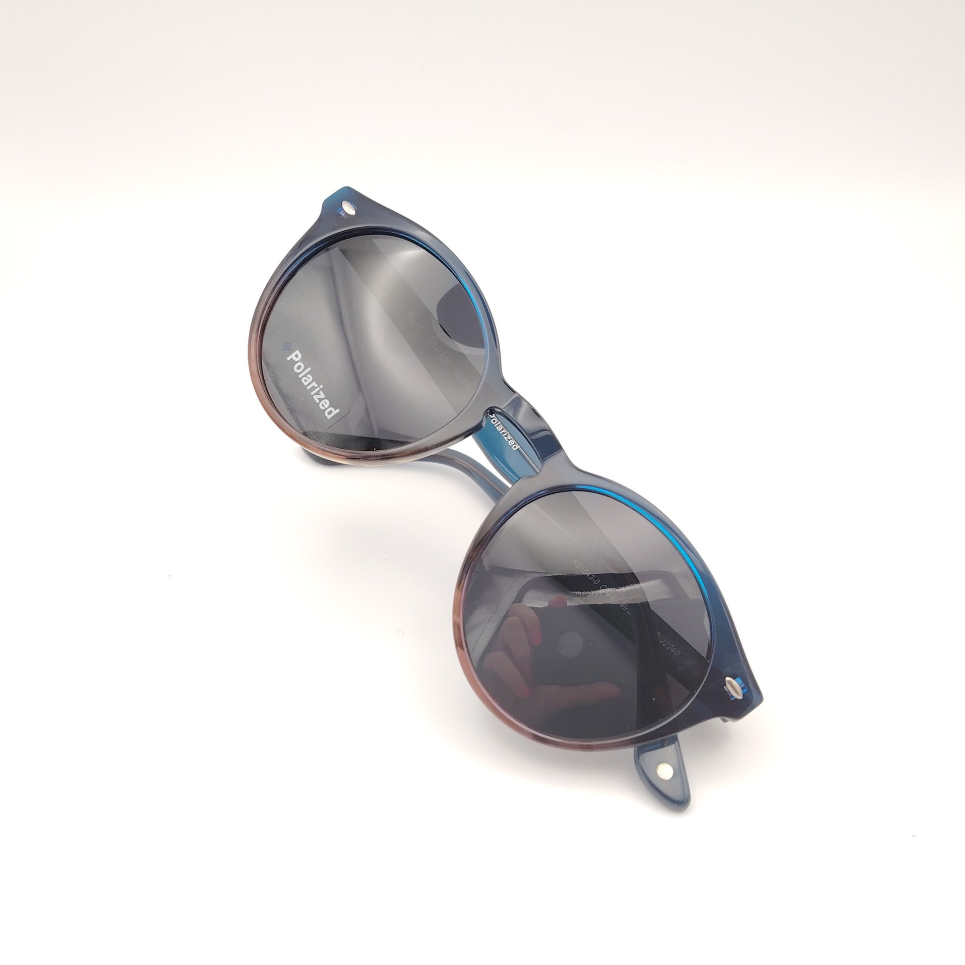 gafas de sol rischio r21043  c333 redondas de color azul y marrón con lentes polarizadas oscuras